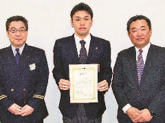 Mr. Harashima (center) receiving the certificate of thanks with Tatsuya Yoshinami, Manager of the Meiji University Baseball Team (at right)