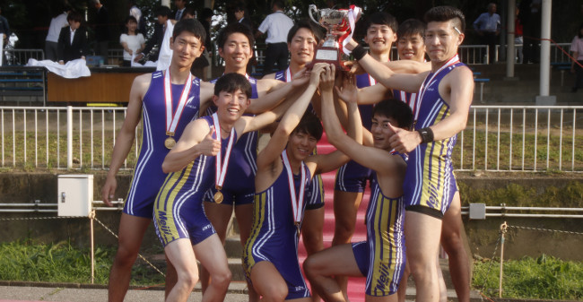 The nine members of the men’s eight squad beaming as they hold up the winner’s trophy<br/>
 (photo by Meidai sport newspapers club)