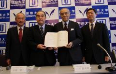 President of Meiji University and Chairman of IUJ holding the agreement after the signing ceremony. (Surugadai Campus)