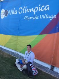 リオ五輪選手村前の芝生に座り記事を書く橋本ATR Japan編集長