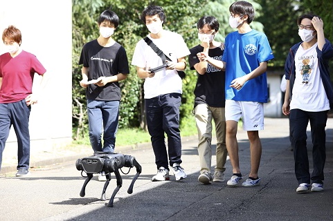教室を飛び出し、最先端の犬型ロボットに触れる生徒ら
