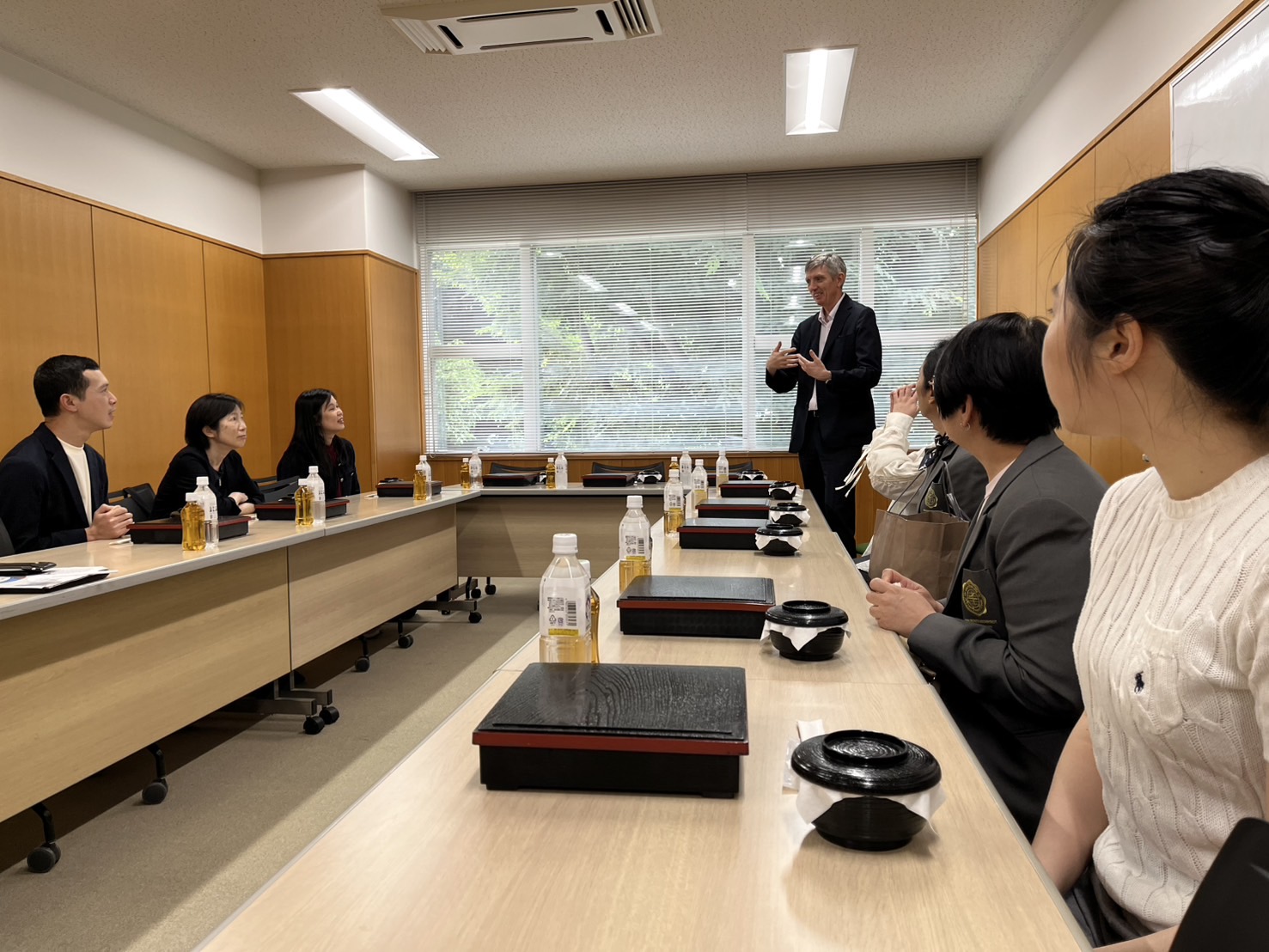 学生を含めて日本食の弁当を囲む