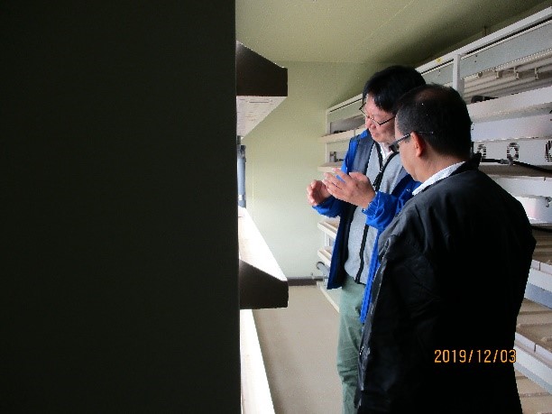 （写真2）甲斐特任講師から閉鎖系苗生産システム「苗テラス」で説明を受けるメディナ博士