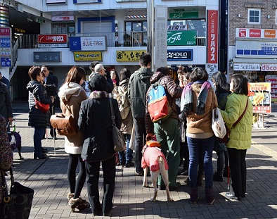 誘導のため明大駅前で待ち合わせる学生たちと視覚障がいの方々