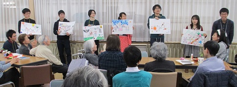 各テーブルで完成した紙芝居を前に立ち披露する学生たち