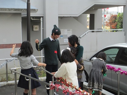 会場近辺の飾りつけをする学生と子どもたち