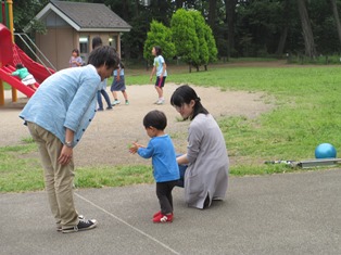 竹とんぼで遊ぶ大学生と子ども