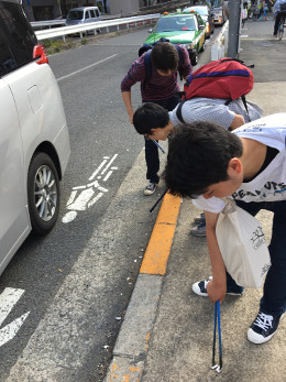 甲州街道にポイ捨てされたたばこの吸い殻を拾う学生