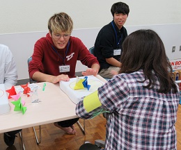 トントン相撲で対決する学生と参加者