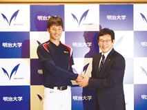 Uehara (at left) shakes hands with Hideki Kuriyama, manager of the Nippon-Ham Fighters.
