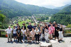 Taking a photo in front of Gassho-style houses (houses with steeply pitched thatched roofs) at Shirakawa-go Village, a World Heritage site 