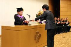 The graduate representative receiving his diploma 