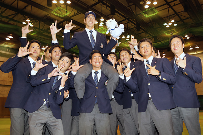 Pitcher Saito smiles as he's carried by his teammates