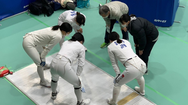 The players in a circle before the game<br/>
<br/>
(photo: Meiji University Fencing Club)<br/>
<br/>
