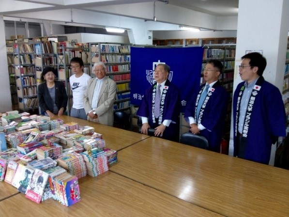 マンガは二宮特任補佐（中央右）から松尾副会長（中央左）へ