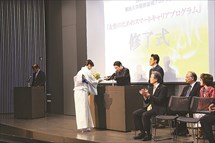 充実した表情で履修証明書を受け取る修了生