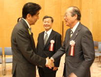 表彰後、安倍首相と握手を交わす向殿名誉教授