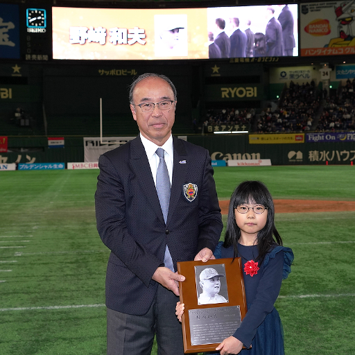 日本アメリカンフットボール協会の国吉会長から盾を受け取る恵那さん