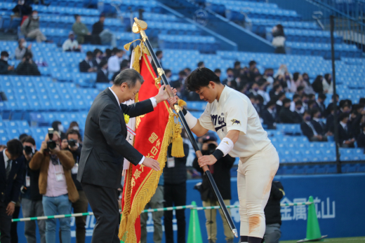 優勝旗を受け取る村松主将（写真=すべて硬式野球部）