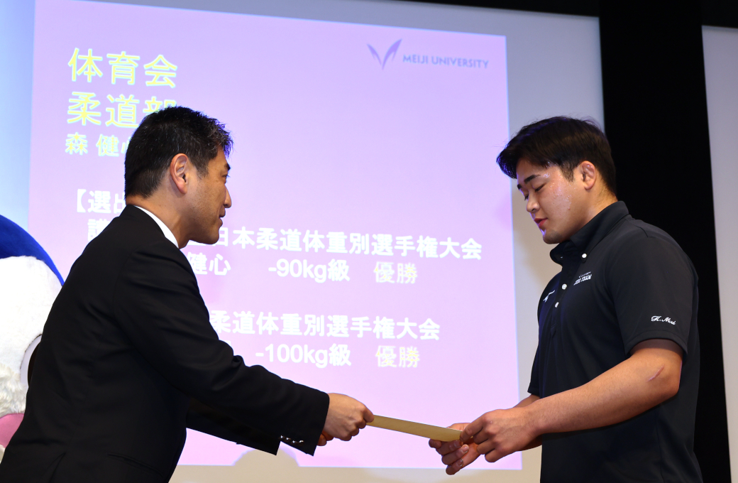 小林尚朗副学生部長（左）から表彰状を授与される体育会柔道部の森さん