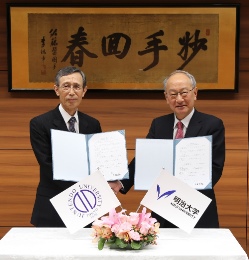 握手を交わす木南英紀順天堂大学学長（左）と福宮賢一明治大学学長（右）