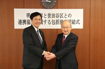 29日には世田谷区で締結式を開催。 調印後、福宮賢一学長（右）と保坂展人区長は固く握手を交わした