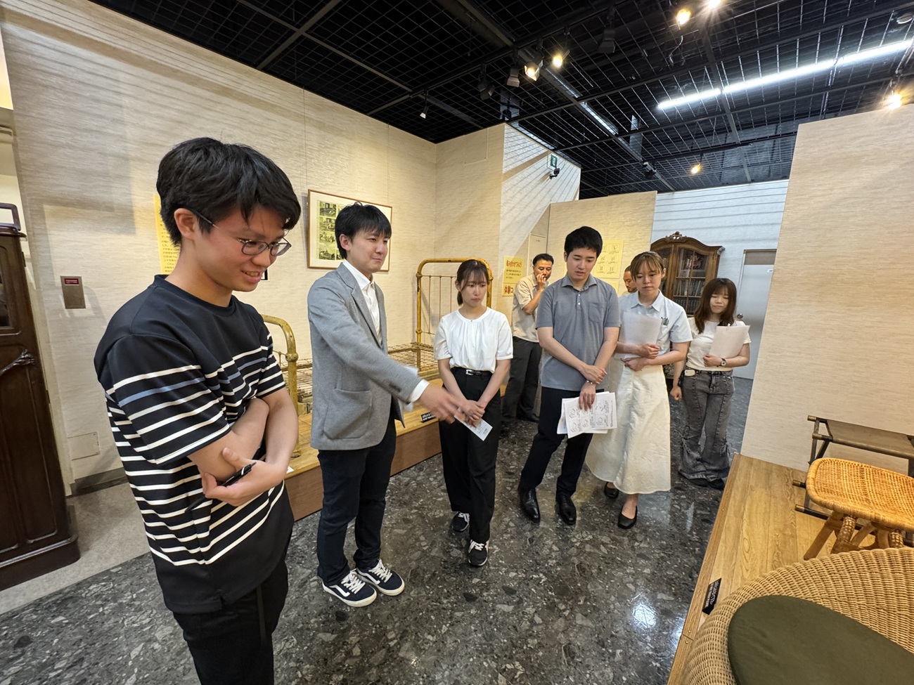 家具の博物館・松田佑斗学芸員（左から2番目）と展示物に関する意見を交わす学生たち