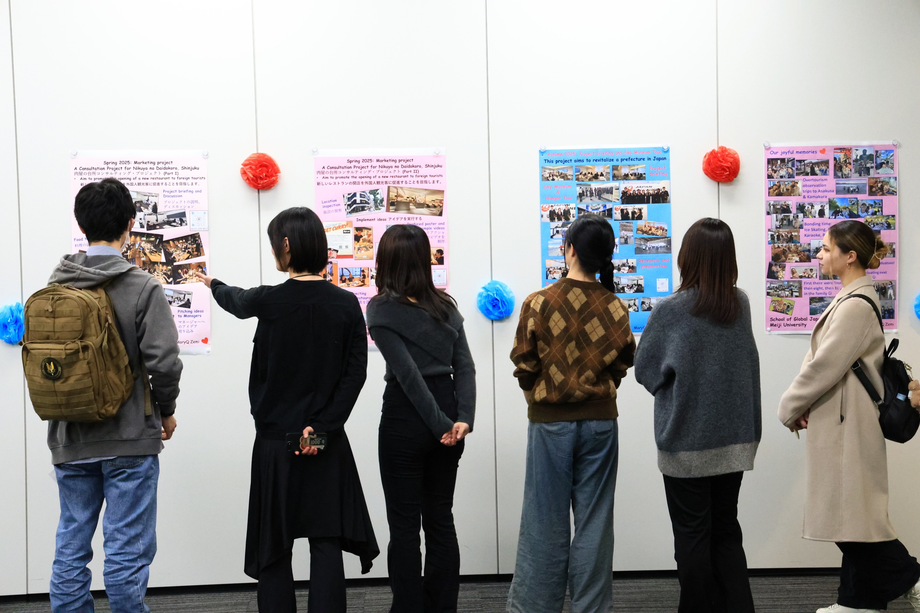 学生の説明に耳を傾ける参加者