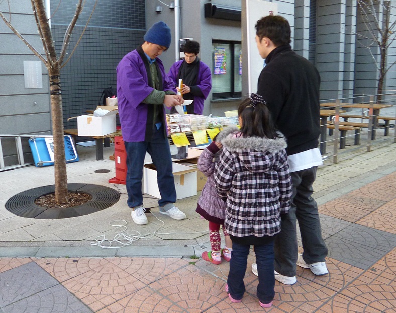 バルーンアートを子どもに披露する学生